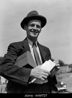 1930s Man in suit with lunch pail and paycheck - Image AAMTDT © ClassicStock
